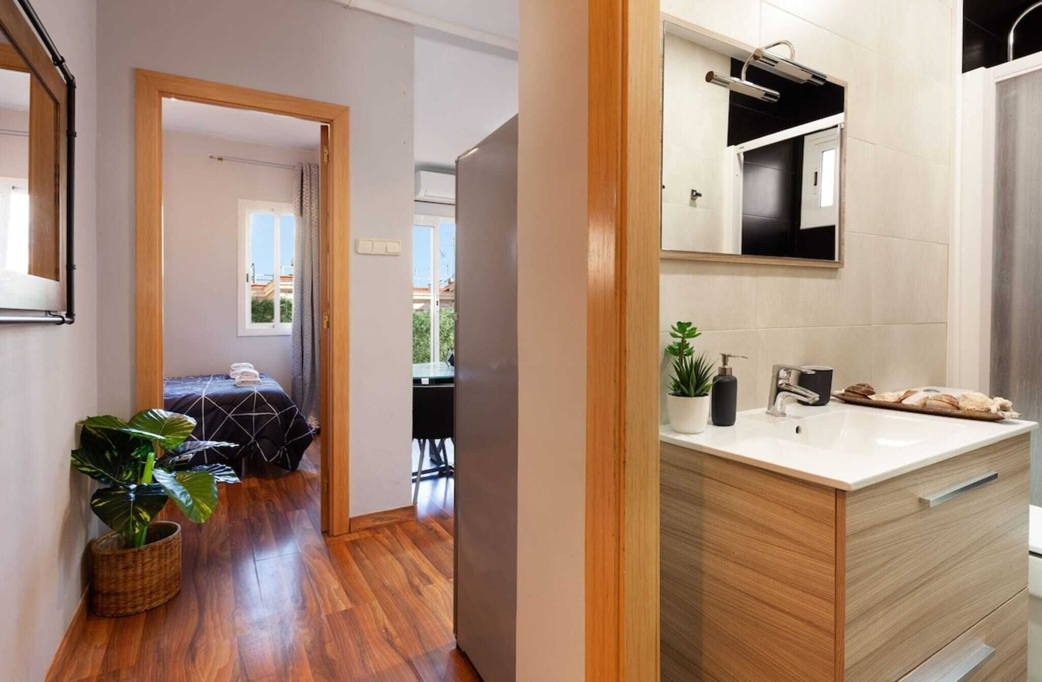 Un baño moderno con lavamanos, espejo y perchero.