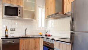 Eine moderne Küche mit Holzausstattung, Edelstahlgeräten und einer weißen Fliesenspritzschutzwand.