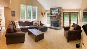 A spacious living room with a sectional sofa, a coffee table, and a fireplace.