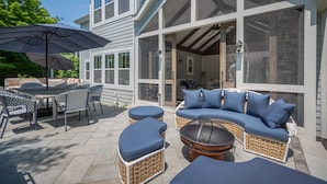 Un patio con mobiliario exterior, incluyendo una mesa, sillas y un sofá.