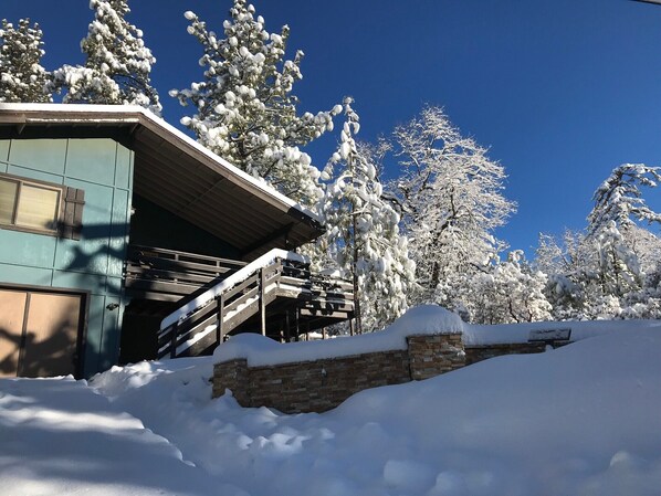 A building with a staircase leading up to a porch, surrounded by snow-covered trees. - Beautiful Mtn Views, Hot Tub, short walk to Cafe Aroma (monthly rental) (Idyllwild-Pine Cove)