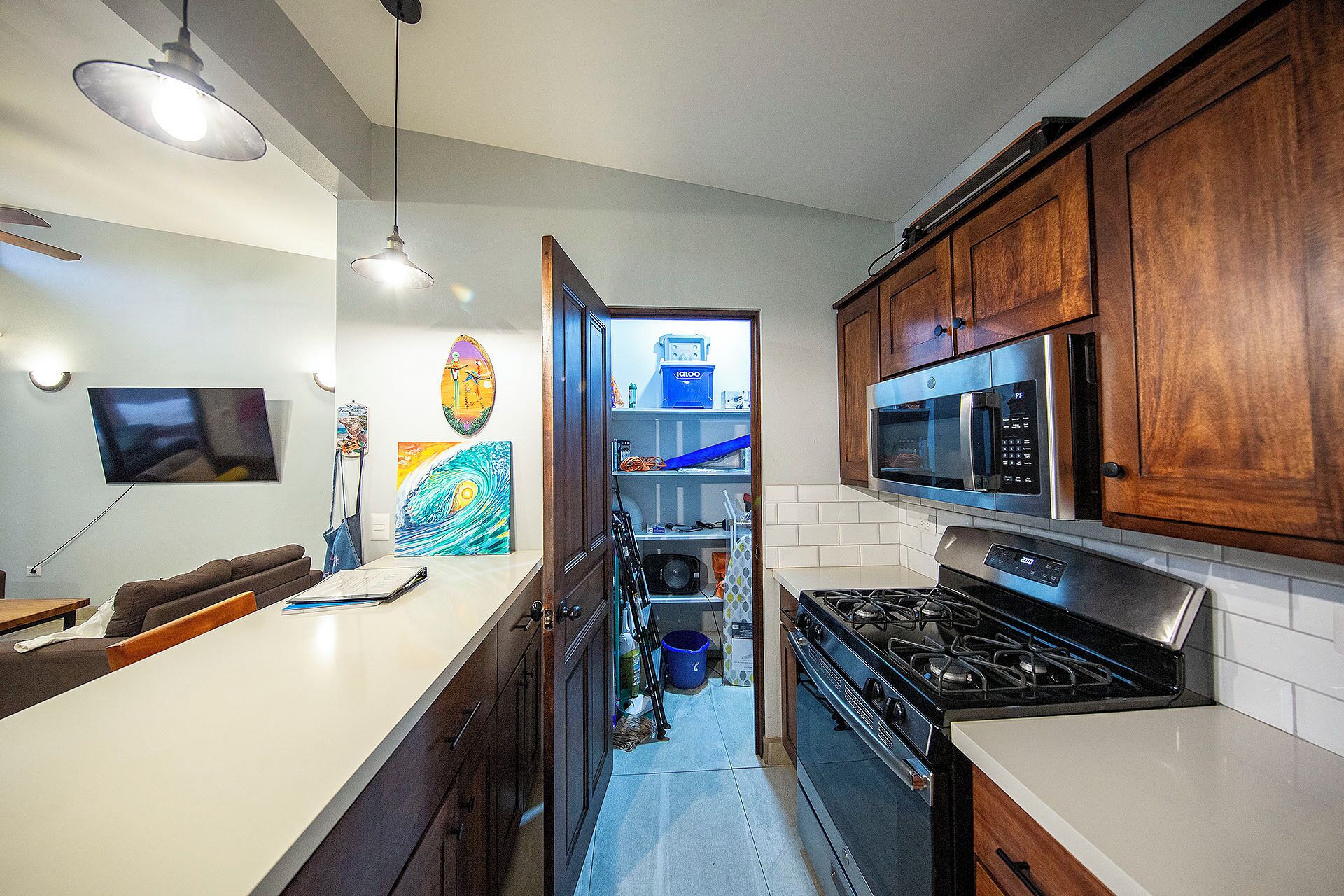 A modern kitchen with wooden cabinets, a stainless steel microwave, and a gas stove.