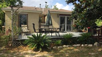 A house with a patio, outdoor furniture, and a covered seating area.