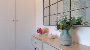 Ein Badezimmer mit Spiegel, Waschtisch und Blumenvase sowie einer Wand mit Muster.