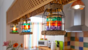 A kitchen with a colorful checkered backsplash, a wooden countertop, and hanging lanterns with a rope base. - Bright apartment with terrace and parking in the center (Málaga)