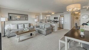 A modern living room with a sofa, coffee table, and dining area. - Oceanfront 3rd floor Balcony 2 blocks to Turnaround-Work Remotely (Seaside)