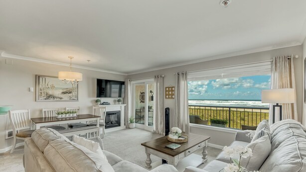 A spacious living room with a fireplace, a dining area, and a balcony with a view of the ocean. - Oceanfront 3rd floor Balcony 2 blocks to Turnaround-Work Remotely (Seaside)