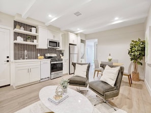 Cozy living space with a round coffee table, armchairs, and a dining area.