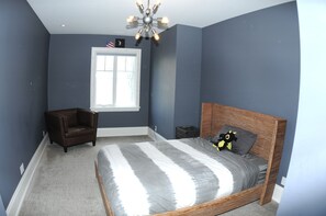 Relax in this serene bedroom with a large bed, window view, and comfortable seating area.