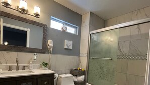 Un baño moderno con tocador, inodoro y ducha.