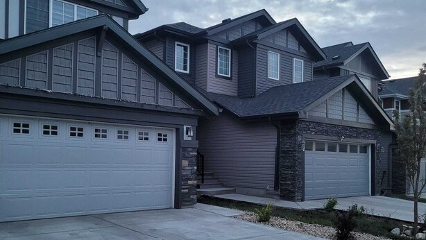 A modern two-story house with a garage and a driveway.