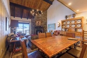 A cozy dining area with a large wooden table, chairs, and a fireplace. - Large Slopeside Condo w/ Fireplace and Great Views; Ski-in/out. (Mt. Crested Butte)