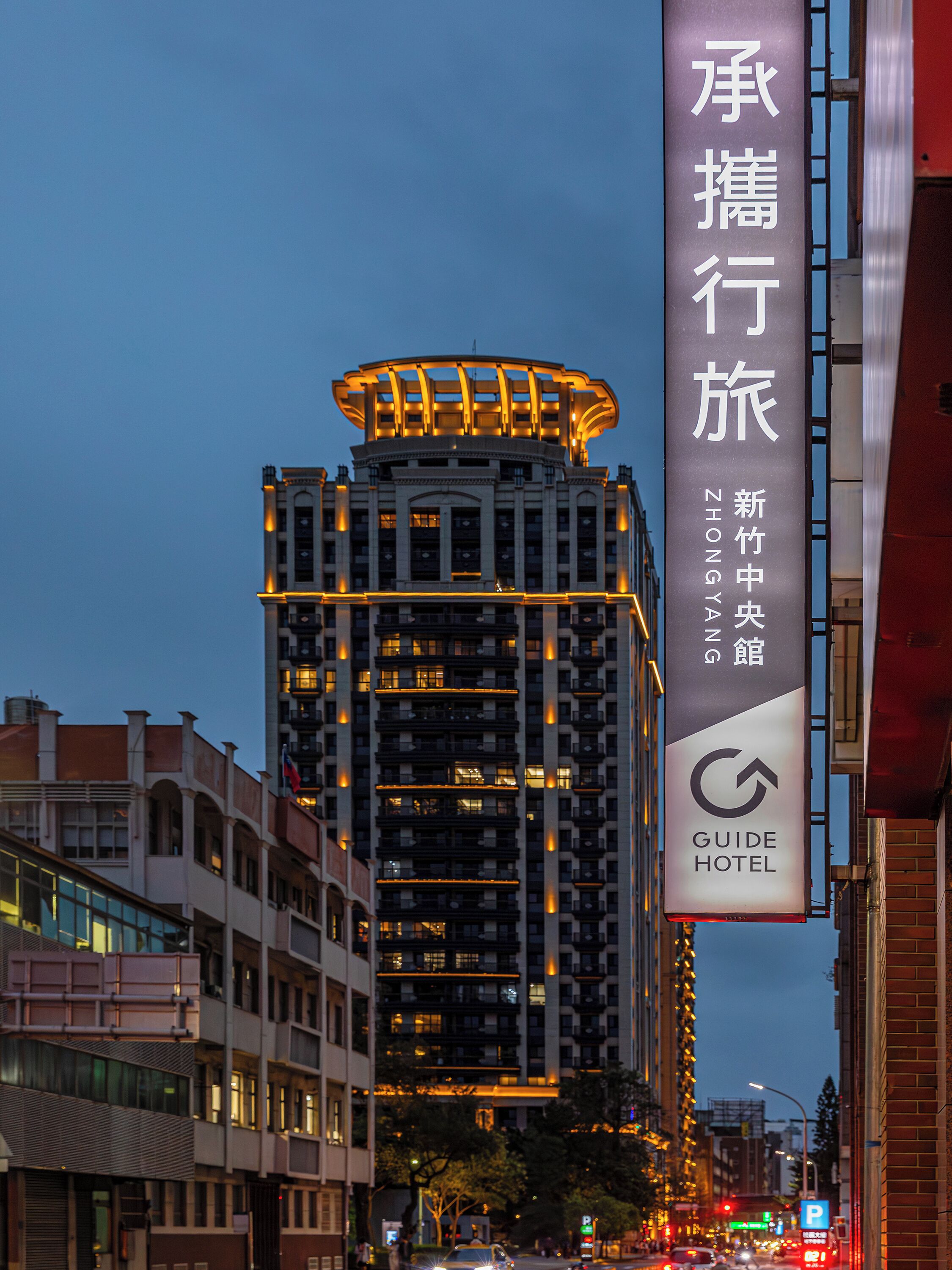 A hotel building with illuminated signage, a prominent entrance, and a modern architectural design.