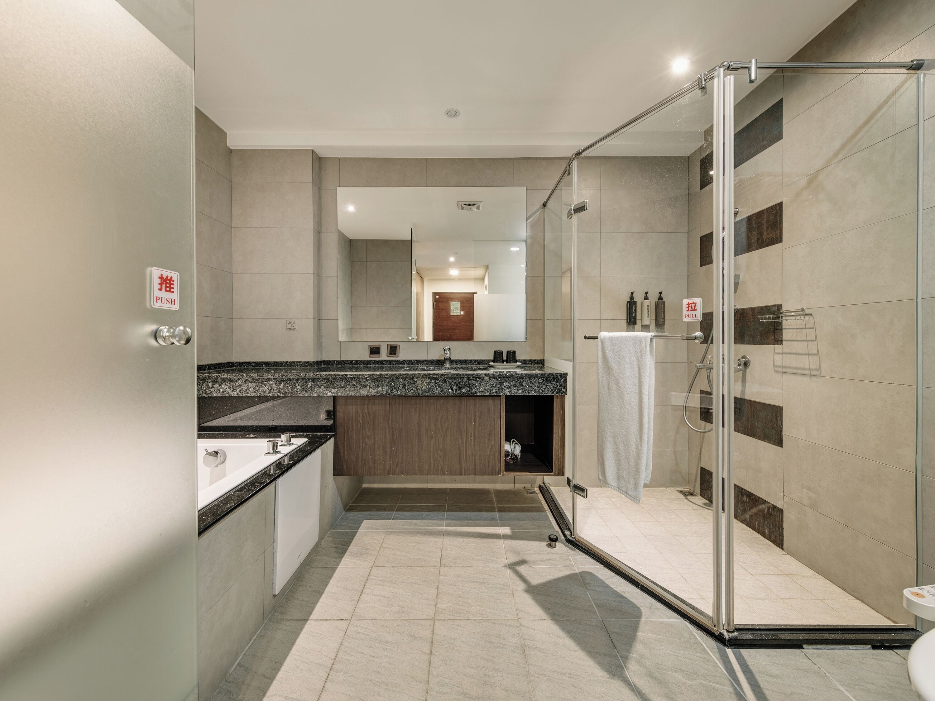 A modern bathroom with a glass shower enclosure, a sink, and a mirror.