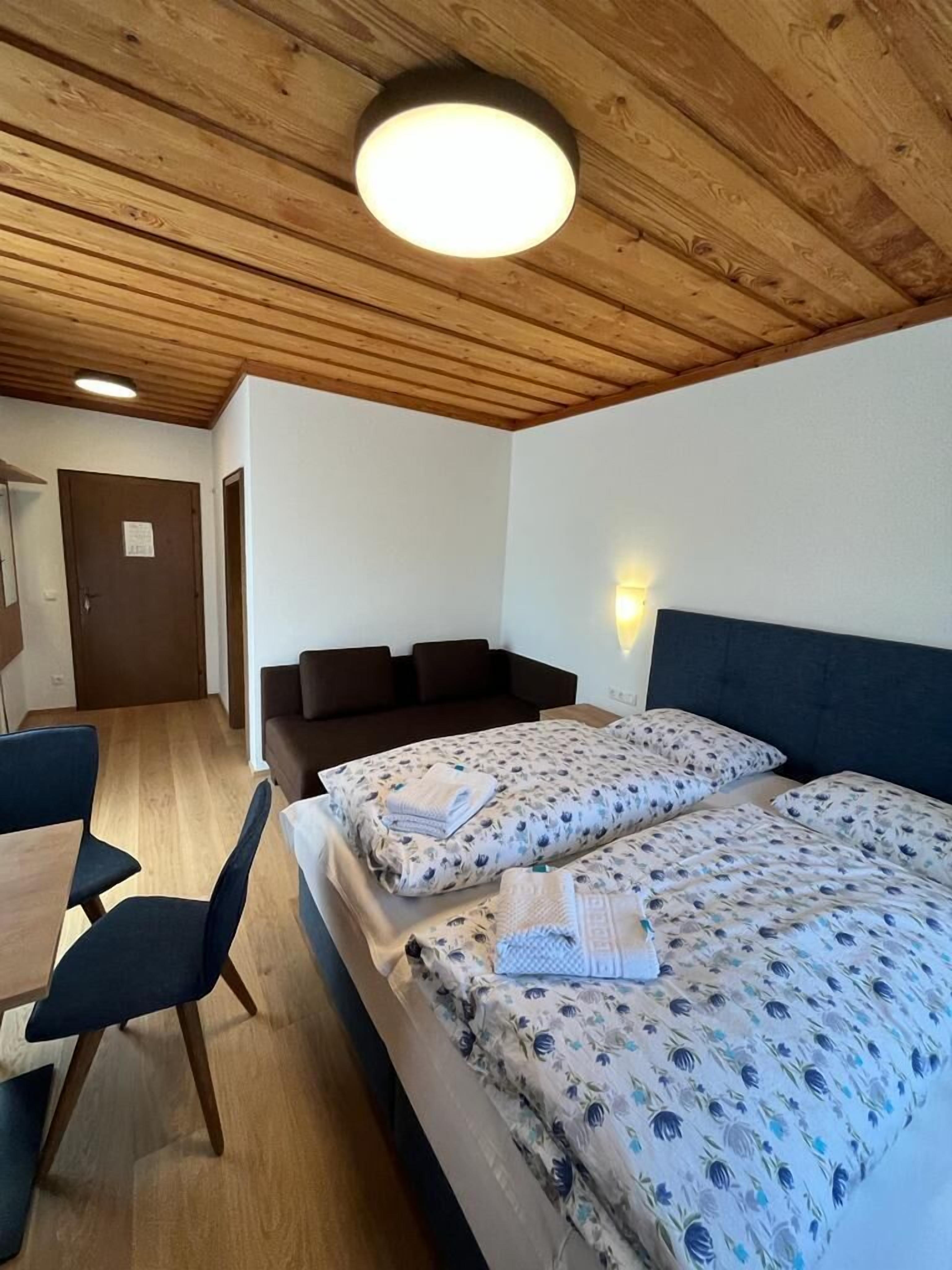 Una habitación con dos camas, un sofá, una mesa y una silla.