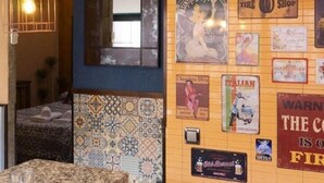 Eine Bar mit Dartscheibe, einem Coca-Cola-Schild und verschiedenen Vintage-Postern an der Wand.