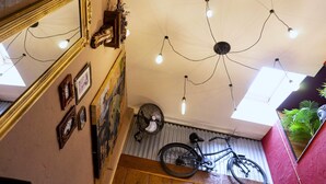 Eine Treppe mit einem Fahrrad, einem Ventilator und einer Deckenleuchte.