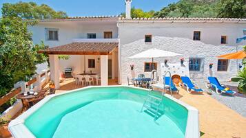 Una piscina al aire libre, tumbonas