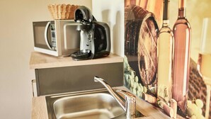 A kitchenette with a stainless steel sink, a coffee maker, and a microwave. - White wine apartment with panoramic view (Stadecken-Elsheim)