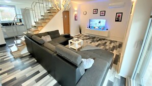 A modern living room with a grey sectional sofa, a coffee table, and a TV mounted on the wall. - LUXURY Apartment 2 floors 3BR! +NETFLIX +HIGH-END (Ližnjan)