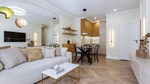 A modern living room with a sofa, coffee table, and dining area.