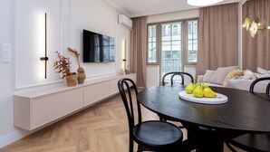A modern dining area with a round table, black chairs, and a white console table with decorative items.