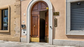A building entrance with a wooden door, a sign above the door, and a window to the left. - GuestHost - Little Venice Charming Flat with Canal View (Livorno)