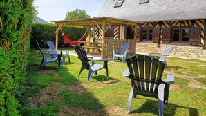 A patio area with outdoor seating and a hammock. - LONGERE NEAR HONFLEUR, DEAUVILLE, LE HAVRE (Beuzeville)