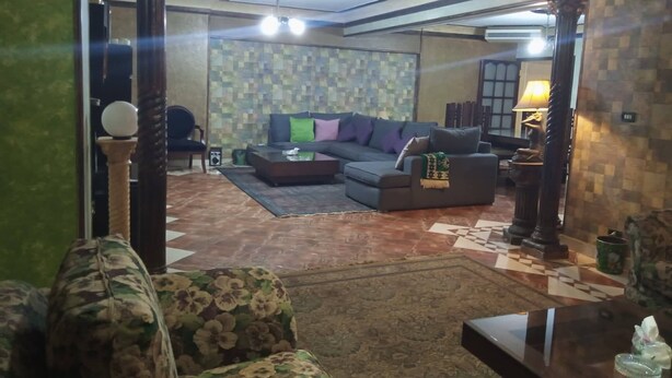 Una sala de estar con un conjunto de sofá, una mesa de centro y una alfombra estampada.