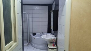 Un baño con bañera, lavabo y ducha.
