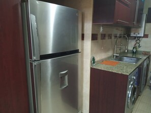 A kitchen with stainless steel appliances, a sink, and a washing machine. - Amazing Apartment with 3 huge bed rooms, 1.5 bath rooms, kitchen & reception.... (Giza Governorate)