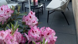 Un patio al aire libre con mobiliario de mimbre, una mesa con velas y una planta en maceta.