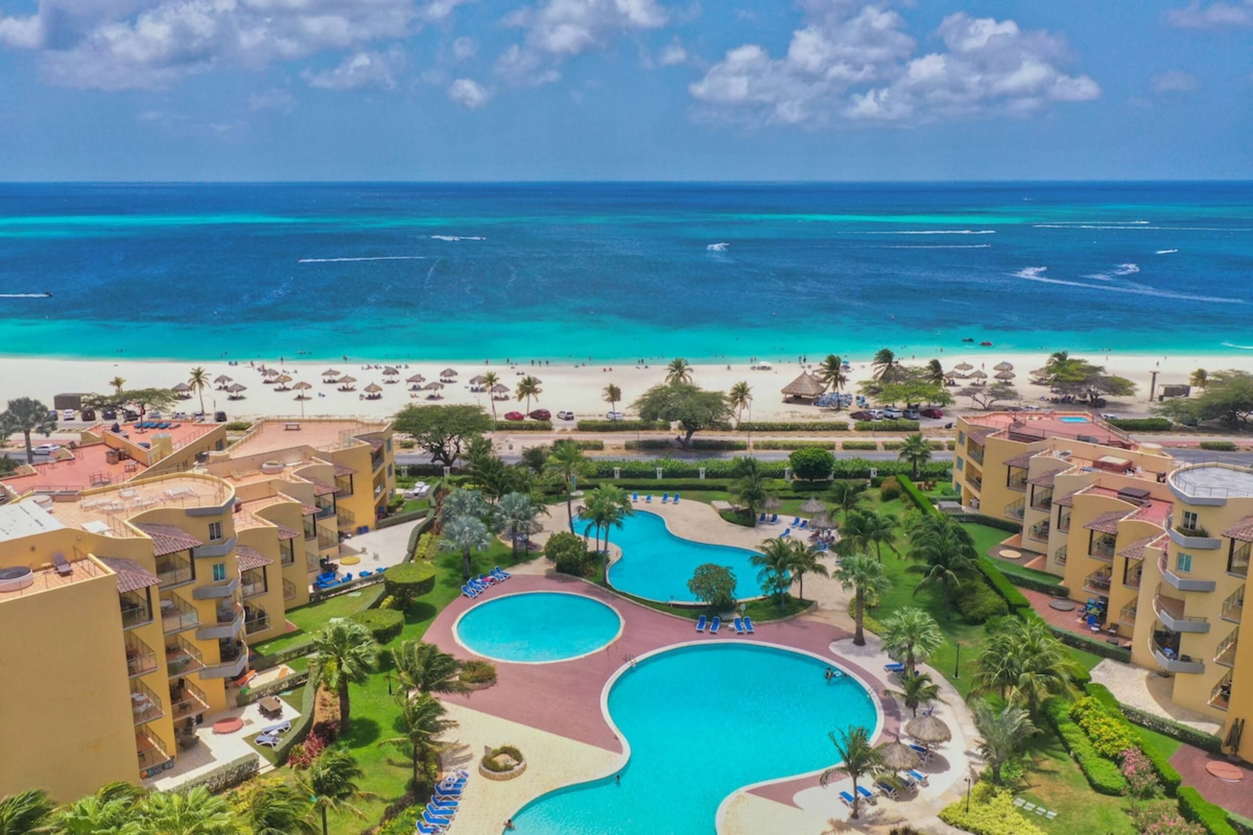 A resort with a pool area, beachfront, and multiple buildings.
