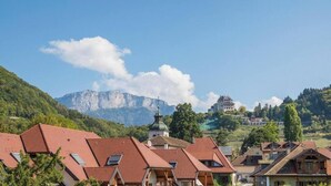 Un pueblo con arquitectura tradicional, una iglesia y una montaña al fondo.
