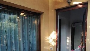 Una habitación con ventana, puerta y suelo de baldosas.
