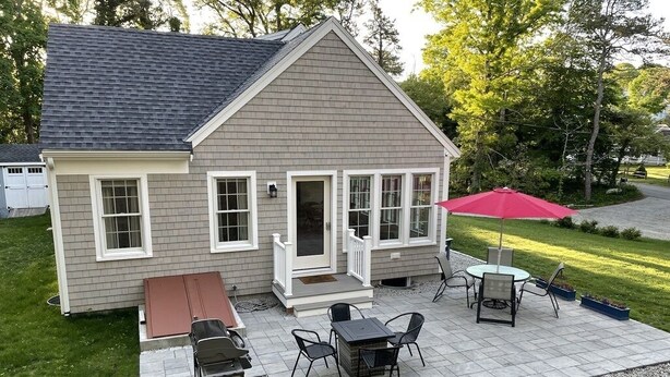 A house with a covered patio, a grill, and outdoor furniture. - New construction within 1 mile of bay beach and Nickerson Park (Brewster)