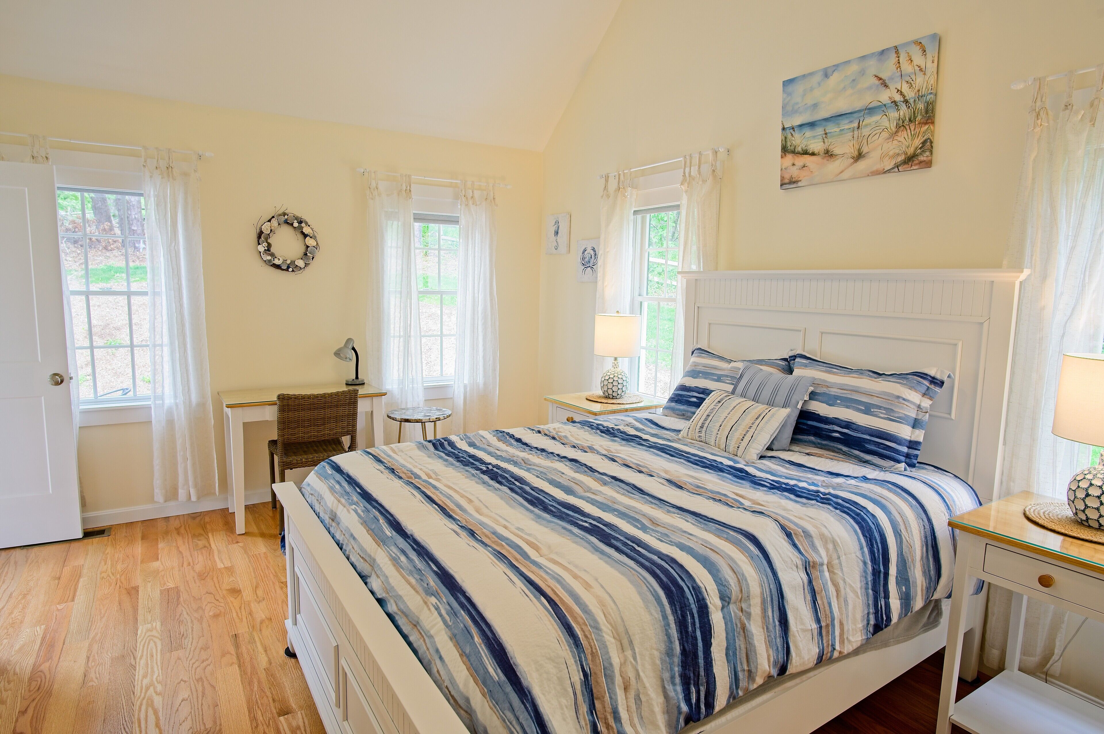 Une chambre à coucher avec un lit, un bureau, une chaise et une fenêtre.