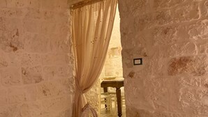 Una habitación rústica con una cama, una mesita y una silla.