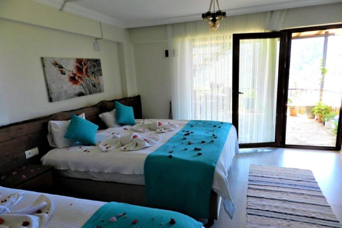 A hotel room with two beds, a large window, and a view of the outdoors.