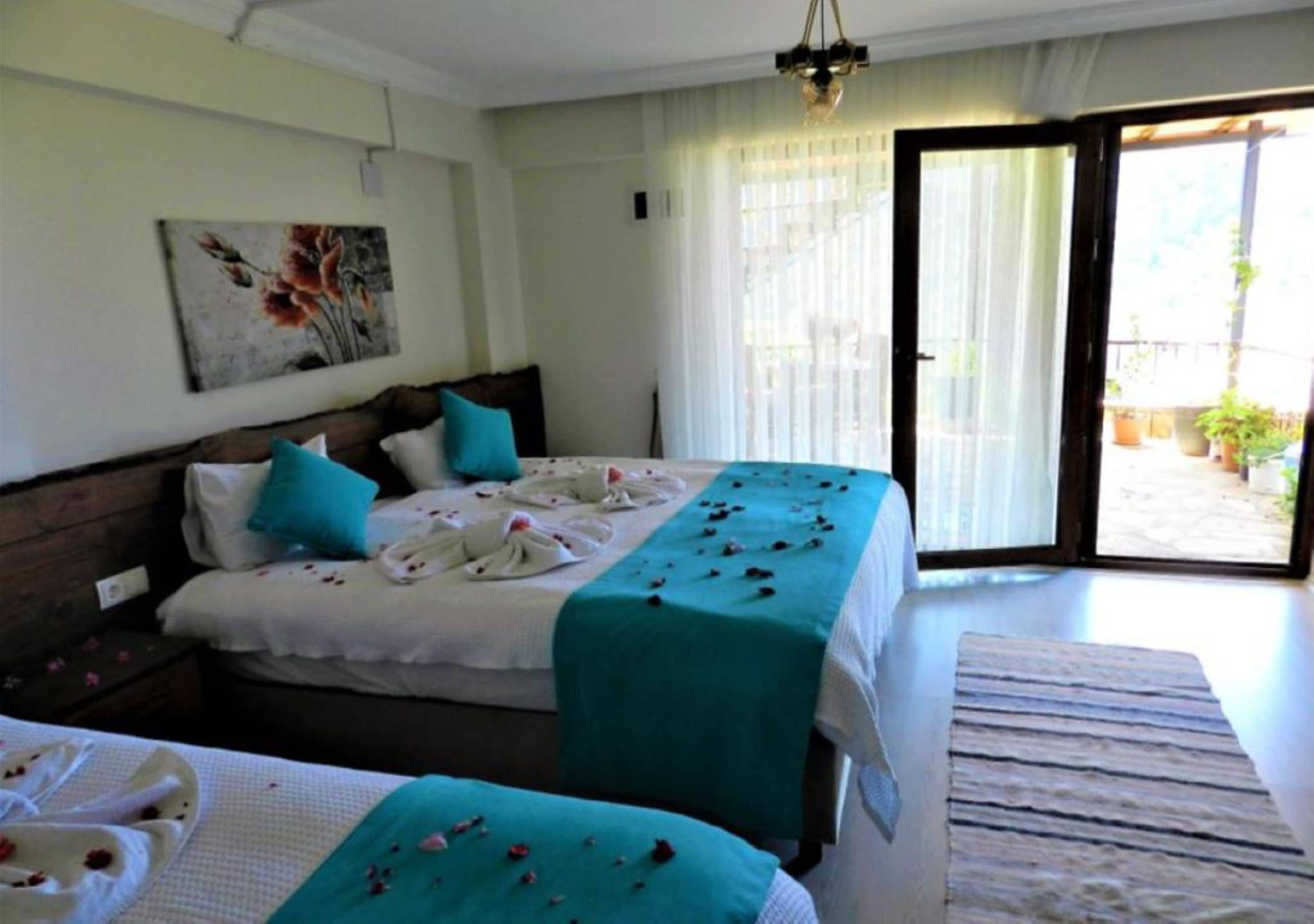 Habitación de hotel con dos camas, un ventanal grande y vistas al exterior.