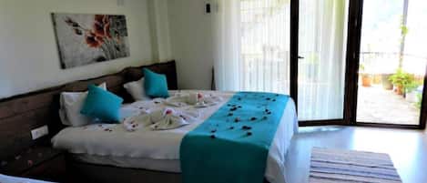 Habitación de hotel con dos camas, un ventanal grande y vistas al exterior.