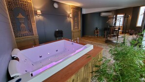 Un baño moderno con una bañera grande, paneles decorativos en la pared y un banco de madera.