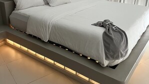 A modern bedroom with a built-in bed, white bedding, and a bedside table. - Seafront Villa in Lagun Curaçao -pool-Wifi + With Private access to sea! (Lagun)