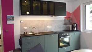 A modern kitchen with a built-in oven, a sink, and a window.