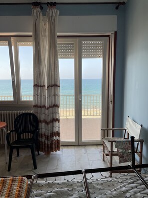 Une chambre avec vue sur la mer, un lit, une chaise et une table.