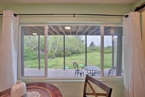 Una habitación con un amplio ventanal que da a una terraza con mobiliario exterior.