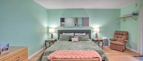 A bedroom with a bed, bedside tables, a chair, a dresser, and a mirror.