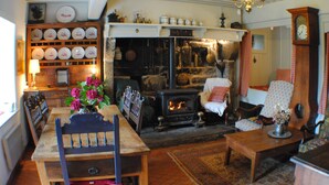 A cozy living room with a fireplace, wooden furniture, and a clock on the wall. - Maison Campagnarde ,parc Clôturé,altitude 1025m (Saint Pierre La Bourlhonne)