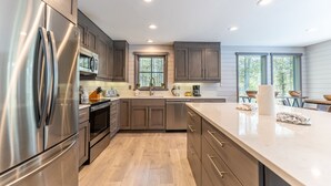 Una cocina moderna con electrodomésticos de acero inoxidable, armarios de madera y una isla grande.