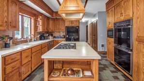 A kitchen with wooden cabinets, a central island, and stainless steel appliances.